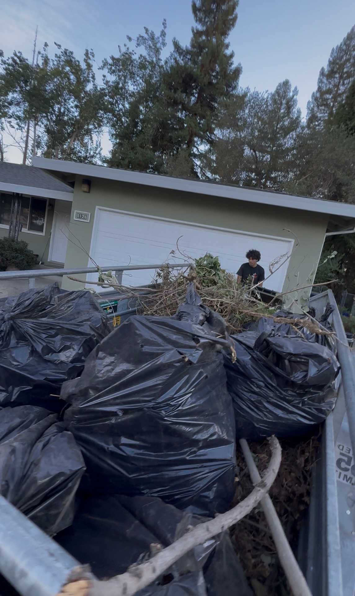 LoadStar trailer filled with trash bags and yard waste on a cleanup job